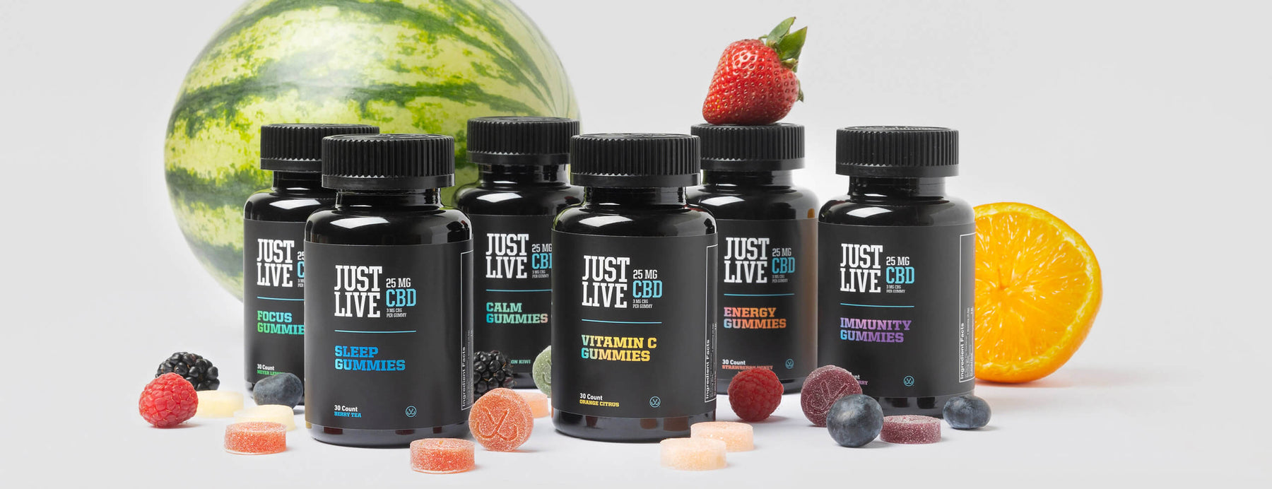 Landscape Image of All Six CBD Gummies from Just Live with Fresh Fruit and Individual Gummies. Benefits of Gummies include: Sleep, Calm, Focus, Energy, Immunity and Vitamin C