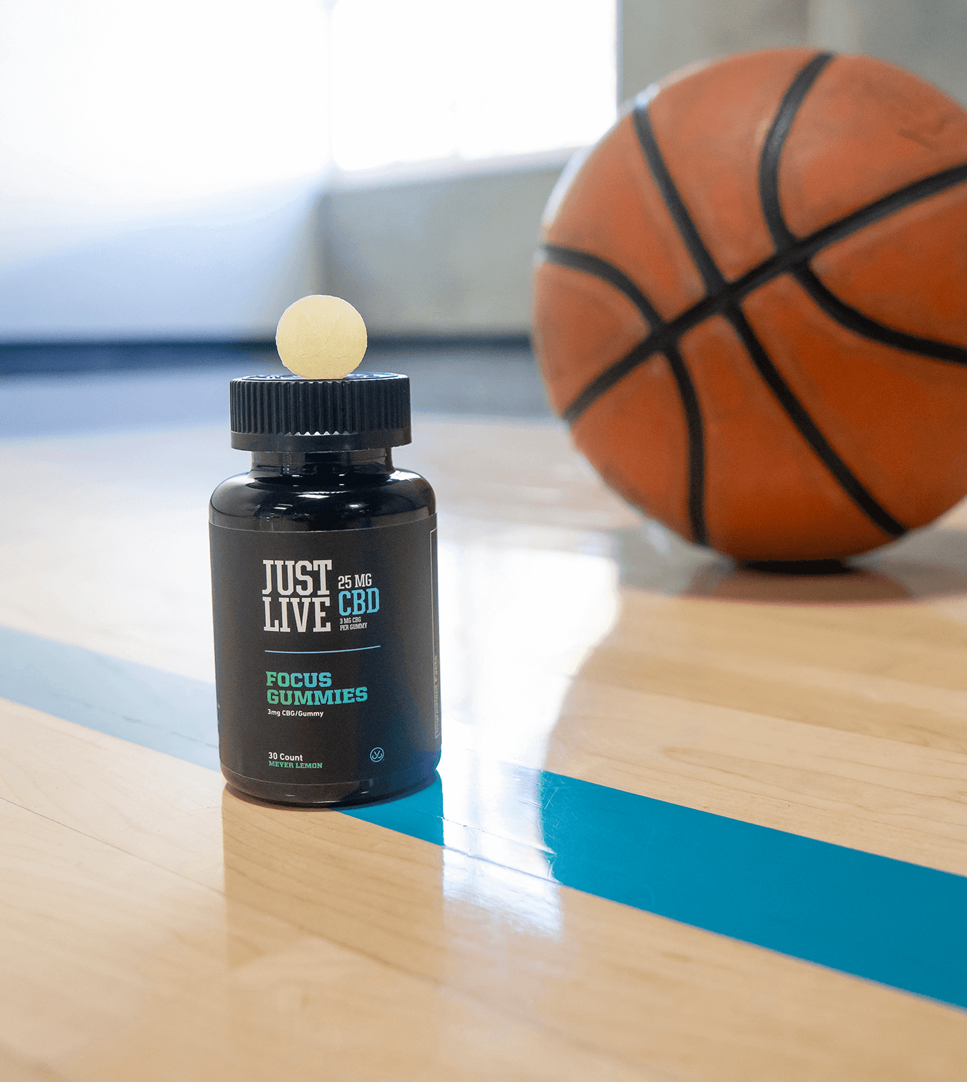 Bottle of CBD Gummies for Stress and Focus on a Basketball Court