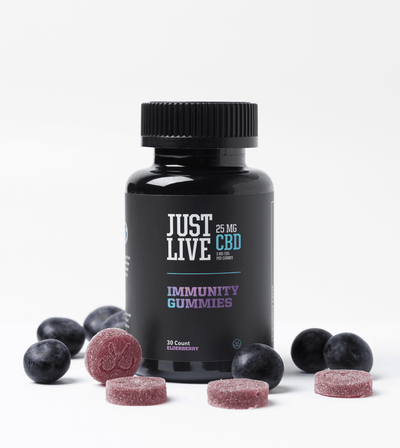 Bottle of CBD Immune System Boost Gummies Among Fruit and Gummies